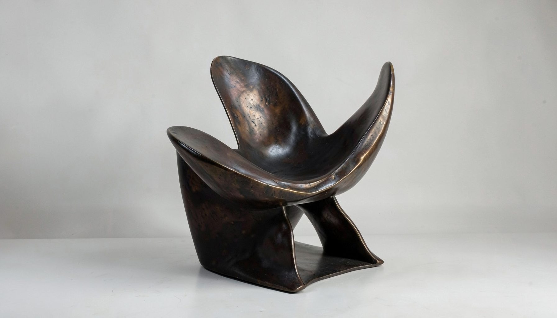 A sculptural bronze chair with sweeping asymmetrical curves, dramatic and contemporary