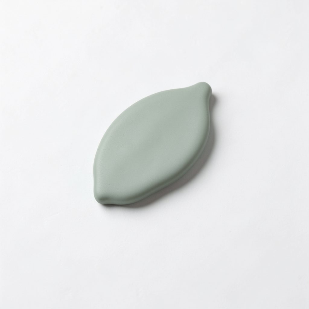 Small rounded leaf emblem in muted sage green, simple and organic